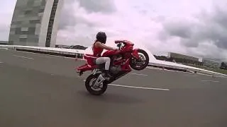 Sexy girl in Santa costume doing acrobatics on the bike.