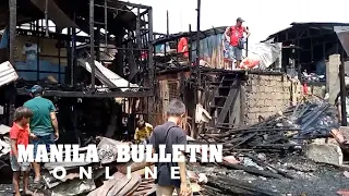 Residents search for usable items after a fire destroyed at least 50 homes