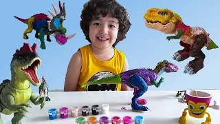 Emin is painting his Jurassic world dinosaur toy
