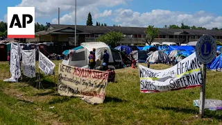 A migrant encampment sits beside a vacant motel near Seattle, highlighting strain of asylum crisis