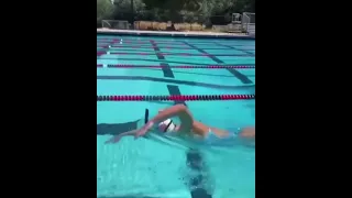 Katie Ledecky, swims the length of a pool with a glass of chocolate milk on her head