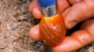 Red diamonds and agate emerge from crevices in rock after torrential rain