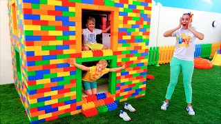 يلعب فلاد ونيكي بمكعبات الألعاب الملونة ويبنان منزلًا ثلاثي المستويات
