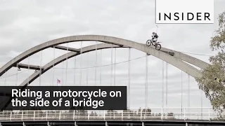 Motorcycle riding on the side of a bridge