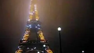 The Eiffel Tower twinkles in the fog