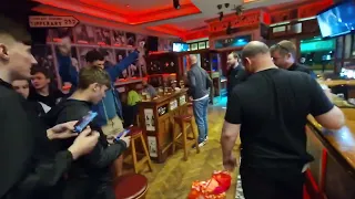 Everton fans celebrate survival by burning a Liverpool flag in a pub