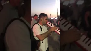 Guy plays "better off alone" on melodica at festival ORIGINAL