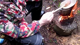 Camp cooking chicken and rice with Polish mess kit and folding stove