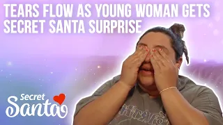 Tears flow down young woman's face after she receives a surprise from Secret Santa