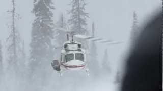 Helicopter takeoff and landing on mountain while snowing