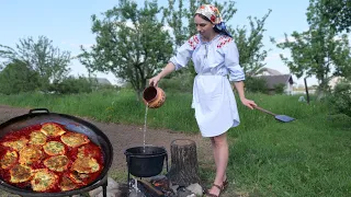 Woman is cooking two amazing dishes in the village. Painting village oven. Ukrainian food