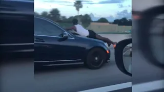 Driver records man riding on hood of car down I-95 in Miami