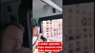 Loader operator drops massive rock into dump truck