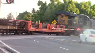 CSX Manifest with flat cars loaded rails crossing Ozzie Davis parkway northbound leaving Rice yard