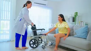 Asian nurse helping young amputee woman,...