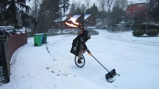 Man Shoveling Snow on a Unicycle Dressed as Darth Vader While Playing Flaming Bagpipes