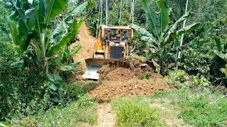 Professional operator BULLDOZER D6R XL works very fast in repairing plantation roads