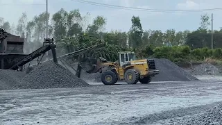 "The excavator gets rocks from the conveyor belt, then transfers them onto the dump truck."