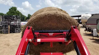 Mahindra 1626 shuttle lifting a 4 x 5 round bale