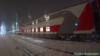 ЭП20-063 прибывает с двухэтажным поездом на станцию Мурманск в полярную зимнюю ночь в снегопад .