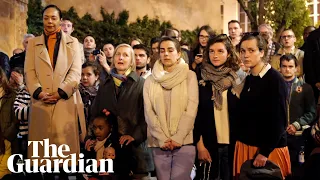Parisians gather outside burning Notre Dame to sing hymns
