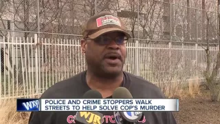 Police and crime stoppers walk street to help solve cop's murder