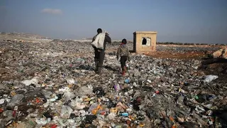 Displaced Syrian children sift through trash to buy bread