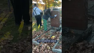 Jewish cemetery vandalized with swastika graffiti; volunteers clean.