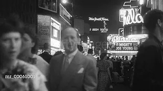 1949 Times Square at night with flashing neon signs and pedestrian and vehicle traffic/New York,