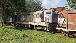 Trem com vagões carregados e revisados acelerando forte na rampa.