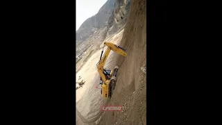 Excavator climbing steep dirt hill