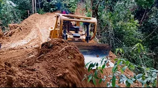 High-risk work BULLDOZER D6R XL cuts through hills on mountains to make new roads