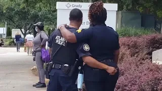 Atlanta police console one another outside hospital following shooting