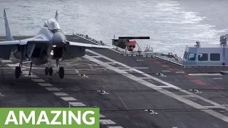 Slow motion footage captures jet fighter landing on aircraft carrier