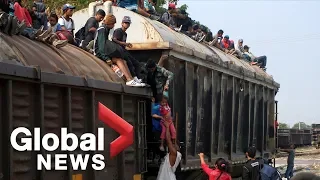 Migrant families in Mexico hitch ride on top of freight train to United States