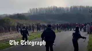 Migrants in life jackets throw rocks at French police to get to dinghies for Channel crossing