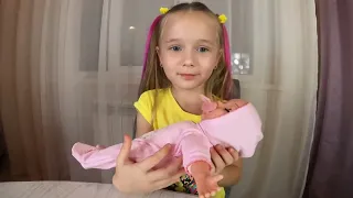 Полина распаковывает и играет с кукла warm baby
