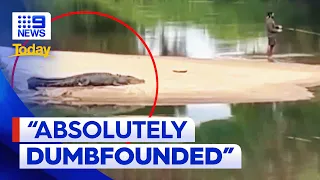 Footage of man fishing metres away from crocodile in Cairns | 9 News Australia