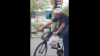 Owner Pokes His Dog While He Sits In The Bike Basket To Look At A Stranger
