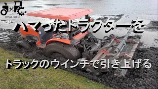 ハマったトラクターをトラックのウインチで引き上げる