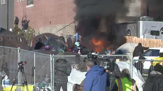 Fire, more buses during Denver migrant camp sweep