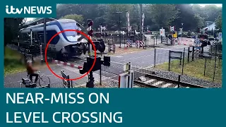 Shocking footage shows pedestrian almost hit by train as she walks on level crossing | ITV News