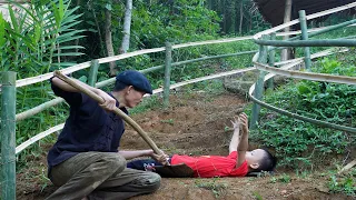 The poor boy helping his father build the fence must be tired of railings and playing happily!