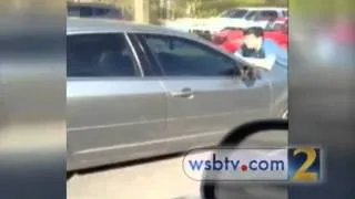 RAW: Man trapped on hood of car