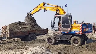 Hitachi excavator heavy equipment working wheel operator loading tata mud in dumptruck