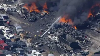Dozens of firefighters worked to extinguish a massive junkyard fire