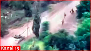 A moving Russian tank is hit - Crew members seek to escape by getting out