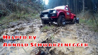 Vintage Rc truck Tamiya toyota hilux on a forest trail with Arnold Schwarzenegger help