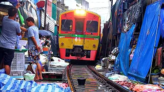 The Train passes through the MaeKlong Railway Market / Поезд едет по товару на железнодорожном рынке