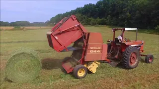 Baling hay with a 1066 black stripe and a Newholland 644 round baler